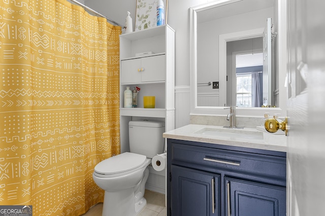 bathroom with tile patterned flooring, vanity, toilet, and curtained shower