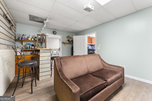 interior space featuring bar, a drop ceiling, and wood-type flooring