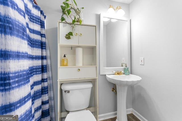 bathroom with hardwood / wood-style floors and toilet