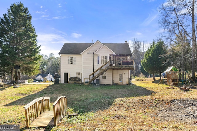 back of house with a playground, a deck, and a lawn