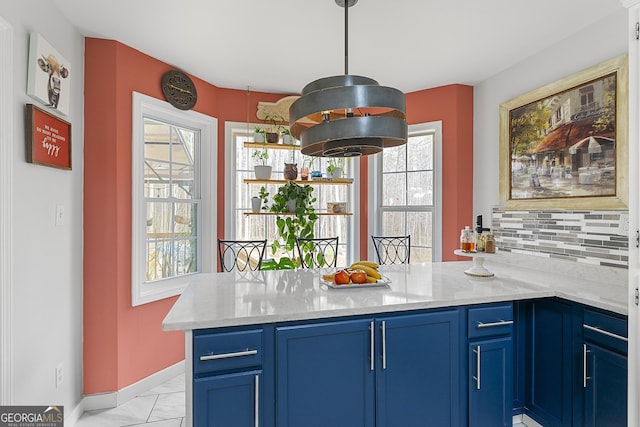 kitchen with kitchen peninsula, blue cabinetry, and a healthy amount of sunlight