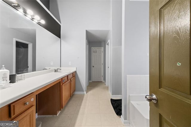 bathroom with tile patterned floors, a tub, and vanity