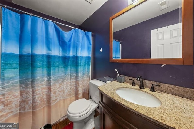 bathroom featuring walk in shower, vanity, and toilet