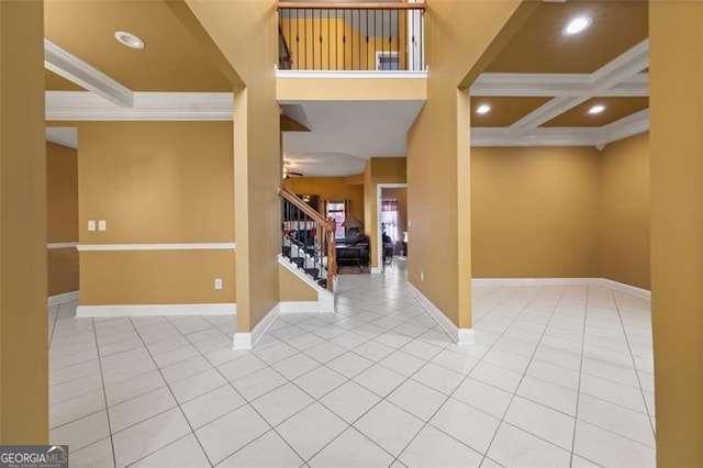 foyer entrance with tile patterned floors, crown molding, and coffered ceiling