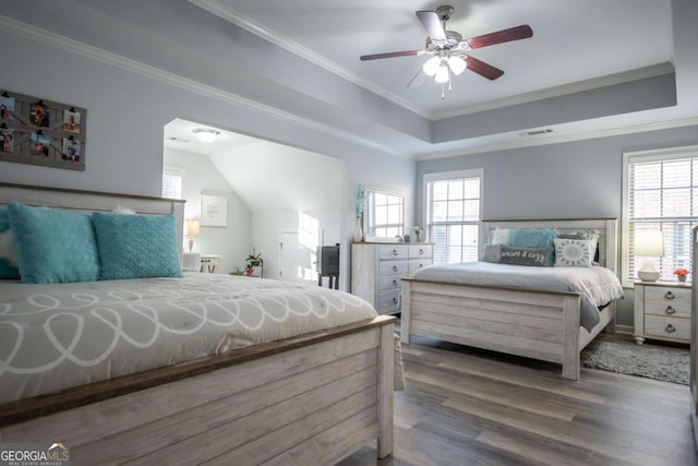 bedroom featuring dark hardwood / wood-style floors, a raised ceiling, ceiling fan, and crown molding