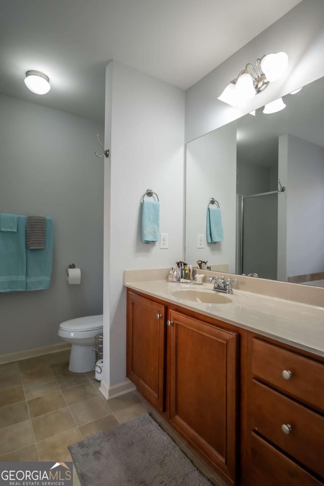 bathroom with tile patterned floors, vanity, toilet, and a shower with shower door