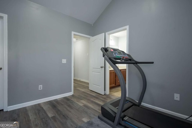 workout area with dark hardwood / wood-style flooring and vaulted ceiling