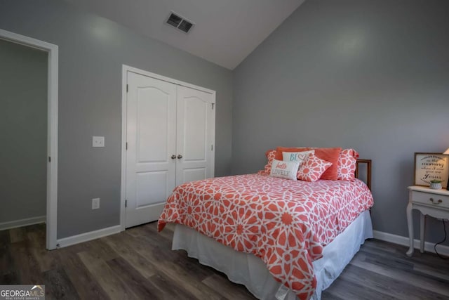 bedroom featuring dark hardwood / wood-style floors, a closet, and lofted ceiling