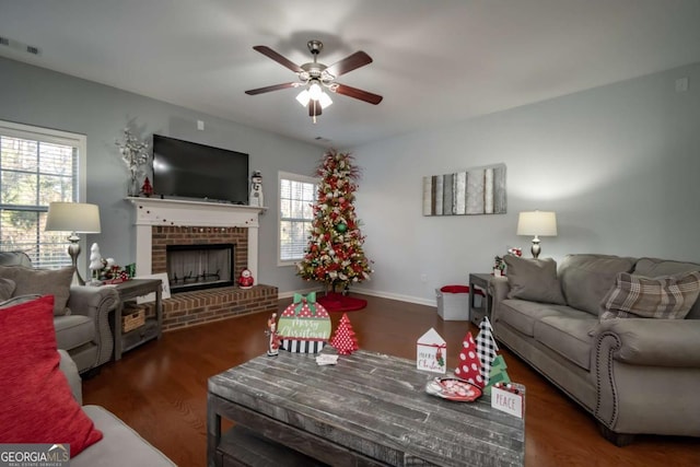 living room with dark hardwood / wood-style flooring, ceiling fan, plenty of natural light, and a brick fireplace