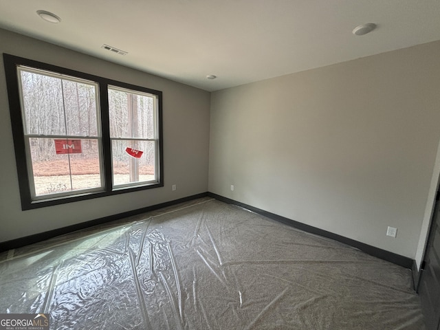 unfurnished room with visible vents and baseboards