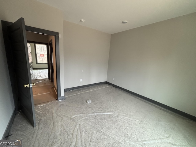 unfurnished bedroom featuring carpet flooring and baseboards