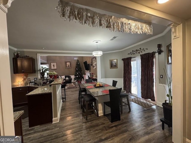 dining room featuring dark hardwood / wood-style floors, sink, and crown molding