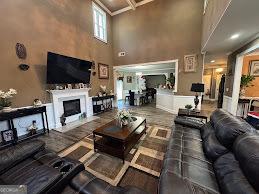 living room featuring a towering ceiling, a fireplace, coffered ceiling, and beamed ceiling