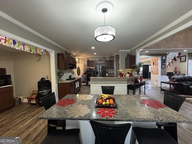 kitchen featuring stainless steel fridge, black microwave, dark wood-style flooring, and crown molding