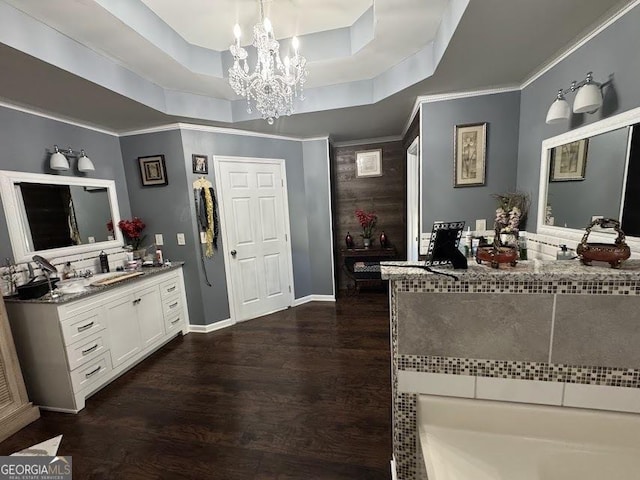 bathroom featuring a raised ceiling, hardwood / wood-style floors, vanity, and an inviting chandelier