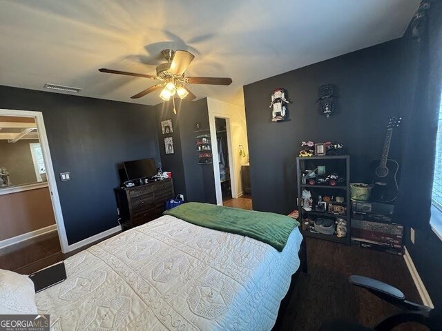 bedroom featuring ceiling fan, wood walls, wood-type flooring, and ornamental molding