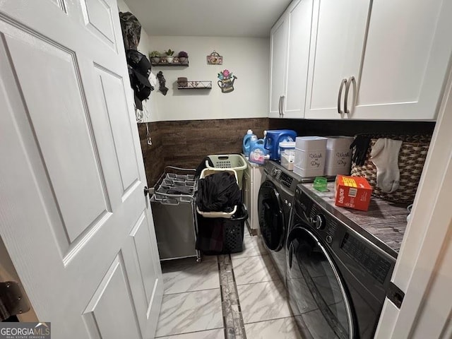 laundry room featuring marble finish floor, cabinet space, and washer and clothes dryer