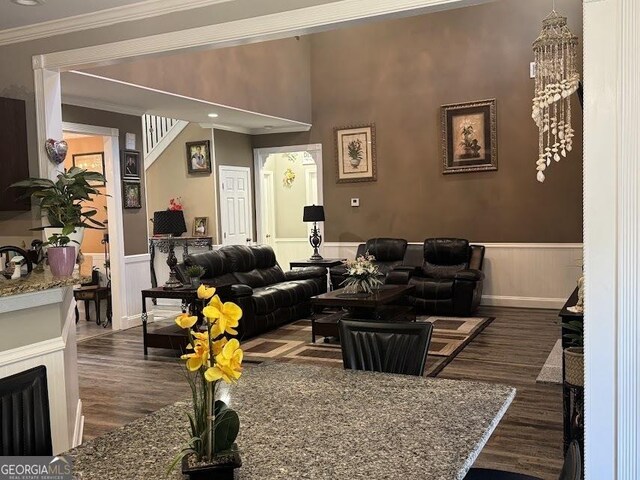 living room featuring hardwood / wood-style floors, a towering ceiling, and ornamental molding