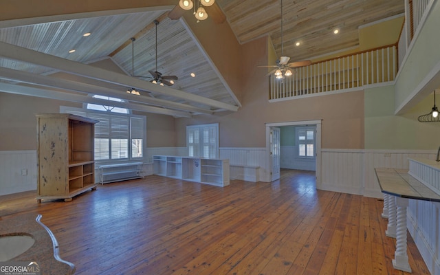 unfurnished living room featuring wood ceiling, ceiling fan, beam ceiling, high vaulted ceiling, and hardwood / wood-style floors