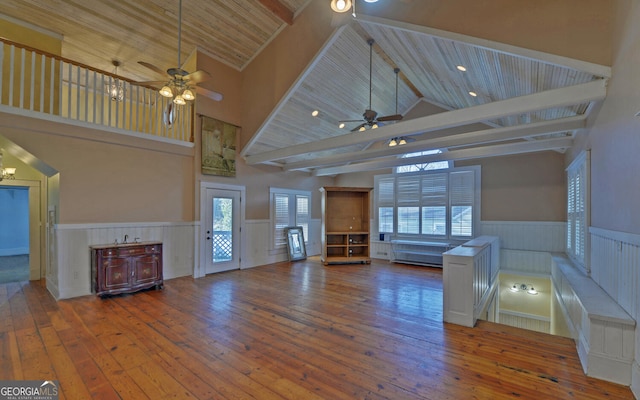 unfurnished living room featuring ceiling fan with notable chandelier, wooden ceiling, dark wood-type flooring, and high vaulted ceiling