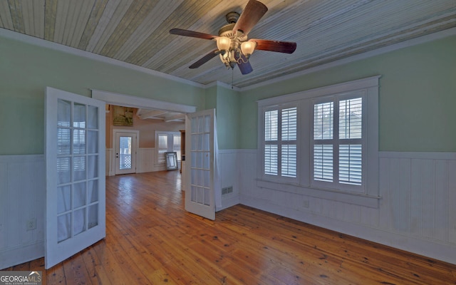 empty room featuring french doors, hardwood / wood-style flooring, ceiling fan, and ornamental molding