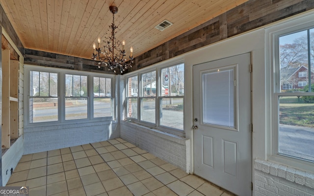 unfurnished sunroom featuring a chandelier, a healthy amount of sunlight, and wooden ceiling