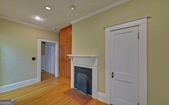 unfurnished living room featuring ornamental molding and light wood-type flooring