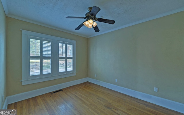 spare room featuring a textured ceiling, ceiling fan, wood-type flooring, and ornamental molding