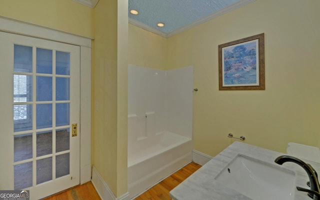 bathroom with crown molding, vanity, wood-type flooring, and a textured ceiling