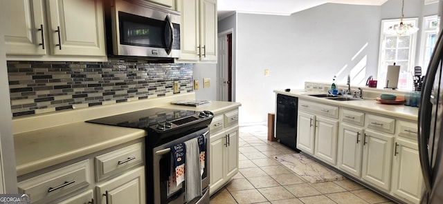 kitchen featuring sink, light tile patterned floors, tasteful backsplash, stainless steel appliances, and a chandelier