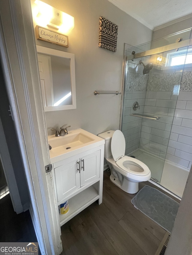 bathroom featuring hardwood / wood-style floors, vanity, toilet, and an enclosed shower