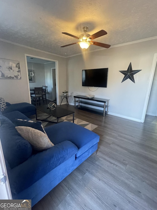 living room with wood-type flooring, a textured ceiling, ceiling fan, and ornamental molding