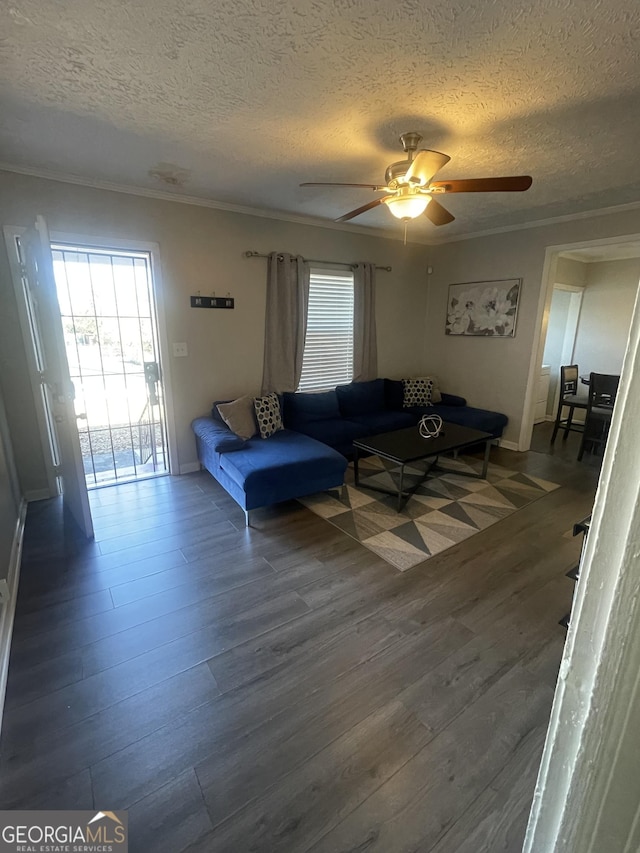 living room with a textured ceiling, dark hardwood / wood-style floors, ceiling fan, and crown molding