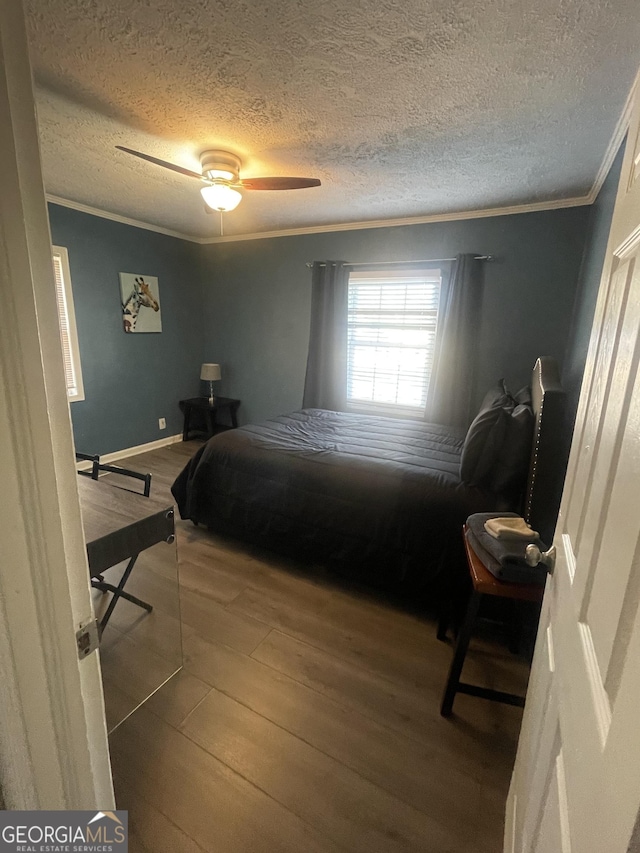 bedroom featuring wood-type flooring, a textured ceiling, ceiling fan, and crown molding