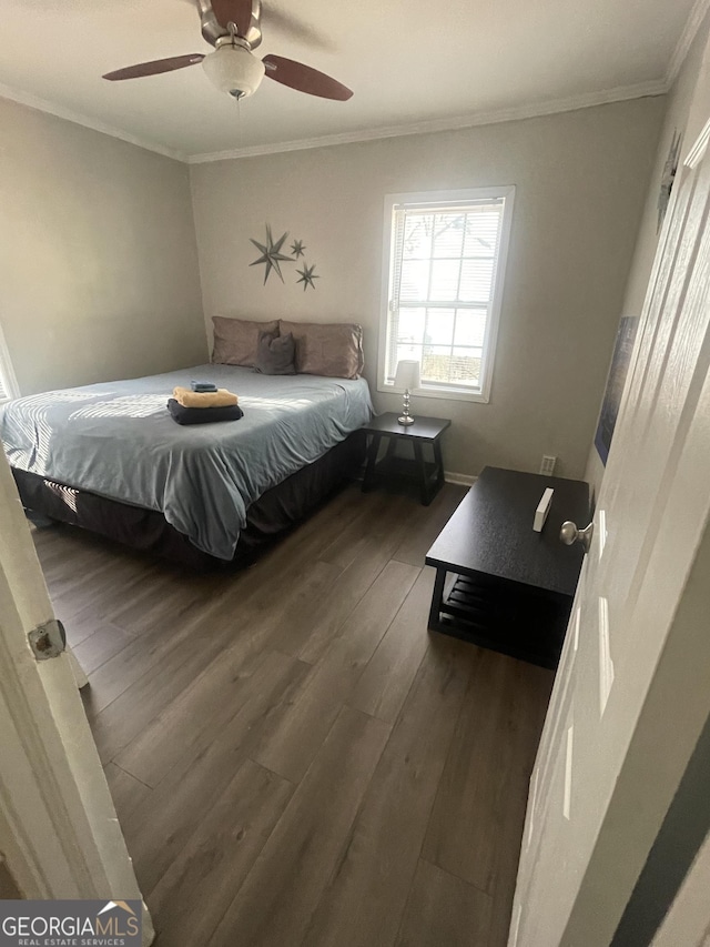 bedroom with dark hardwood / wood-style flooring, ceiling fan, and crown molding