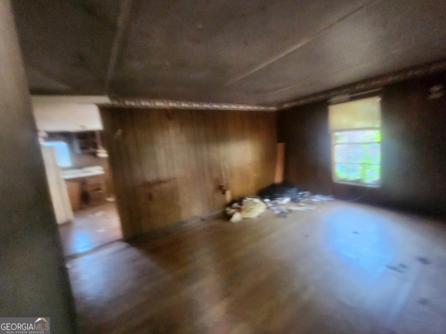 unfurnished room with wood walls and wood-type flooring