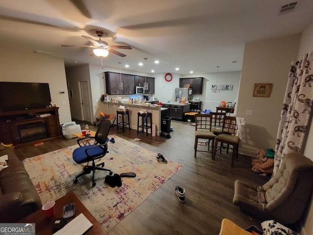 living room with dark hardwood / wood-style floors and ceiling fan