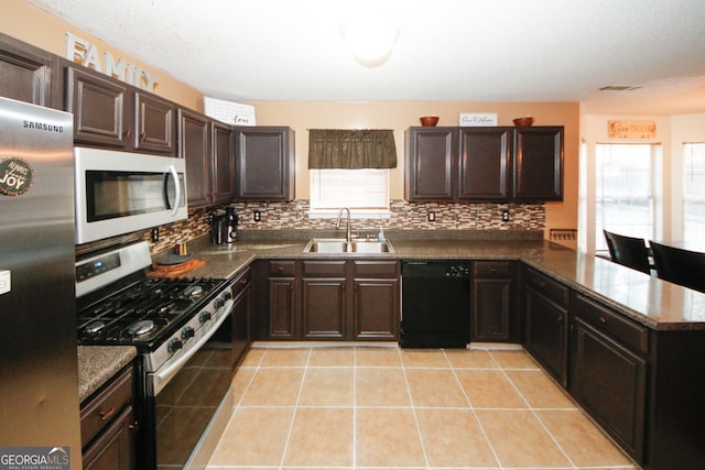 kitchen with light tile patterned flooring, appliances with stainless steel finishes, dark brown cabinetry, and sink