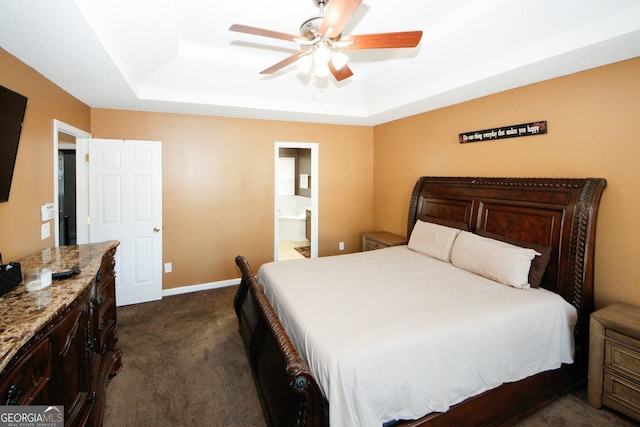 carpeted bedroom with a raised ceiling, ensuite bathroom, and ceiling fan