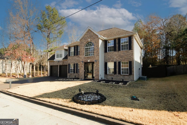 colonial home with a front yard and a garage