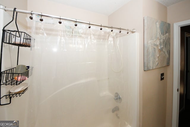 bathroom featuring shower / bath combo with shower curtain and a textured ceiling