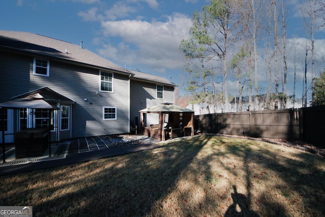 rear view of house with a gazebo, a yard, and a patio