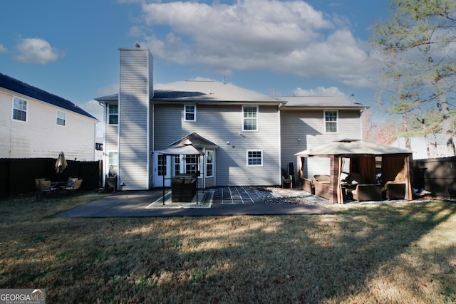 back of property with a gazebo, a yard, and a patio