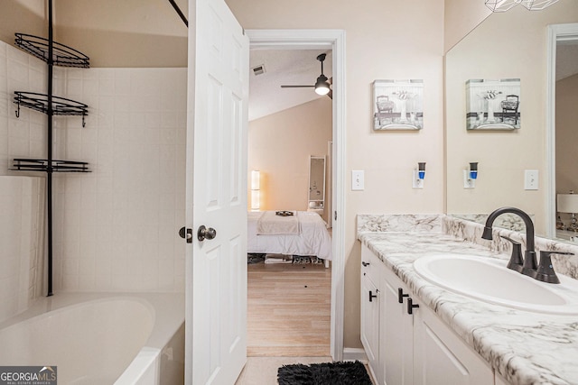 bathroom featuring ceiling fan, vanity, and tiled shower / bath combo