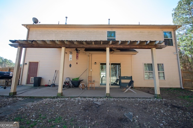 rear view of property featuring a pergola and a patio