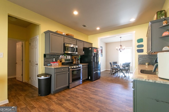 kitchen featuring gray cabinets, dark hardwood / wood-style flooring, stainless steel appliances, and tasteful backsplash