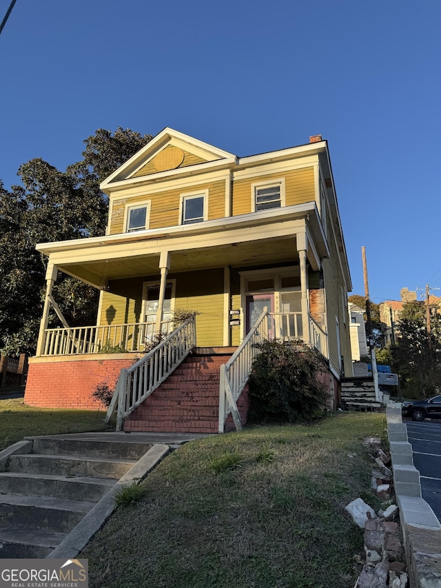 973 Cherry St, Macon, GA 31201 - view of front facade with a porch, stairs, a front yard, and a chimney