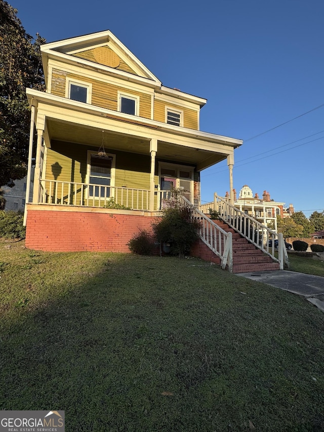 view of front of home with a porch and a front lawn