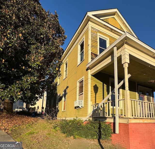 view of side of property featuring cooling unit and covered porch