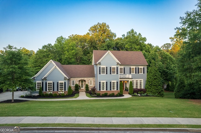 colonial inspired home featuring a front yard